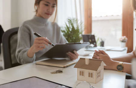 Real estate agent or bank officer describes the loan interest to the customer with home purchase contracts or on office loans and interest rates, selective focusの写真素材