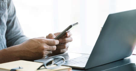 Close up businessman using smart phone at office