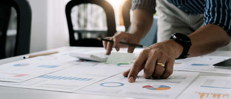 Close up a man working about financial with calculator at his office to calculate expenses,...