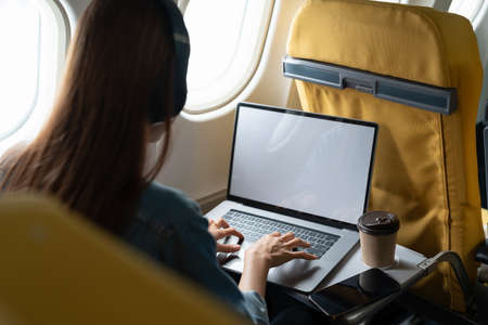 Beautiful asian travel woman using laptop computer in airplaneの写真素材