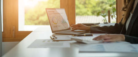 Business woman calculating domestic expenses involved in financial paperwork indoors, focused lady managing monthly banking payments summarizing utility bills and taxes at homeの写真素材