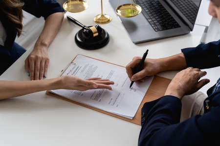 Business people negotiating a contract. Human hands working with documents at desk and signing...