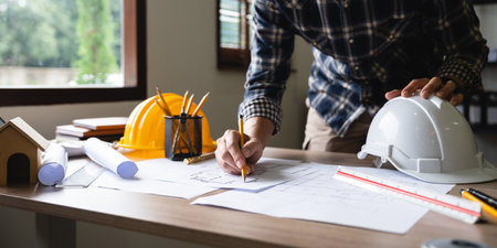 Engineer architect designer freelance work on start-up project drawing, construction plan. architect design working drawing sketch plans blueprints and making construction model. Architects concept.の写真素材