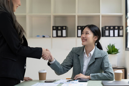 Welcome to our team. close up young modern women shaking hands while working in the creative officeの写真素材