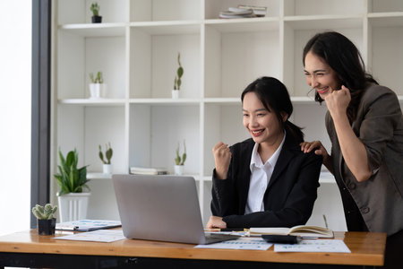 Group of Young Asian business team creative businesspeople coworker in office Happy to be successful partnership teamwork celebrating achievement and success conceptの写真素材