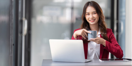 Businesswoman sitting at her desk in an officeの写真素材