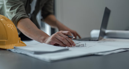 engineer man working in office with blueprints.Engineer inspect architectural plan, sketching a construction projectの写真素材