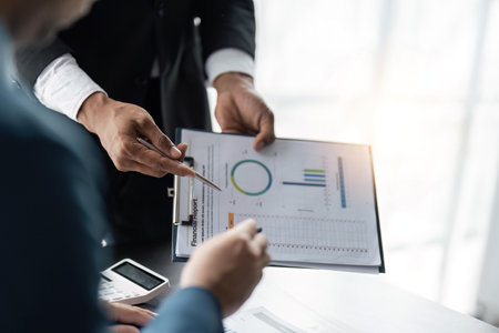 Teamwork process, Business team using a calculator to calculate the of statistic business profits growth rate on documents graph data, desk in the officeの写真素材