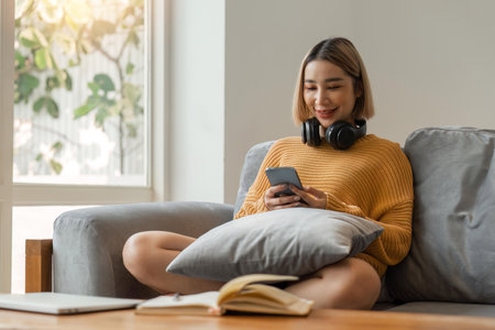 Happy lady relax at home alone sit on couch in comfortable pose share good news at social media via cellphone smiling enjoy weekend order goods food online in phone appの写真素材