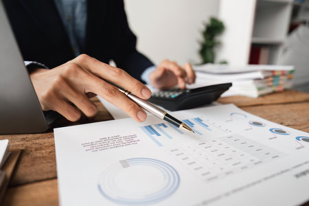 businessman working on desk office with using a calculator to calculate the numbers, finance accounting conceptの写真素材
