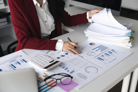 Woman accountant working financial investment on calculator, calculate, analyze business and marketing growth on financial document data graph, accounting, economic, research conceptの写真素材