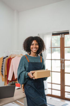 Young attractive woman owner startup business work happy with box at home prepare parcel delivery in sme supply chain, online delivery idea conceptの写真素材