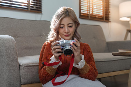 Portrait of pretty young woman looking at pictures from the cameraの写真素材