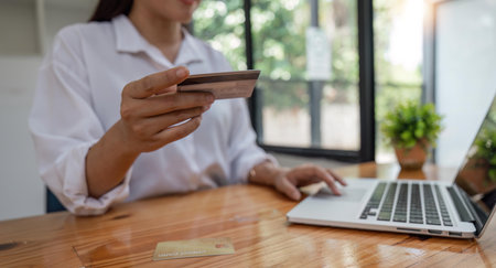 Hands holding credit card and using laptop. Online shoppingの写真素材