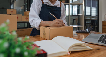 Starting small businesses SME owners, two Asian woman check online orders Selling products working with boxs freelance work at home office, sme business online small medium enterpriseの写真素材