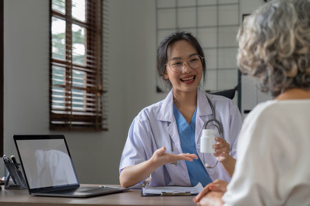 Doctor or physician writing diagnosis and giving a medical prescription to male Patientの写真素材