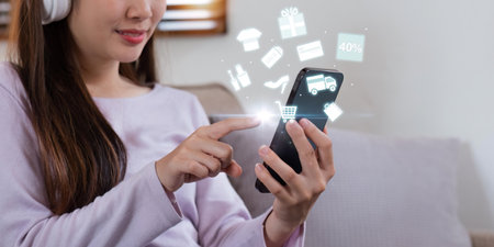 Online shopping and e-commerce concept. Young woman using mobile phone with shopping cart icon, order in online store, shopping on internetの写真素材