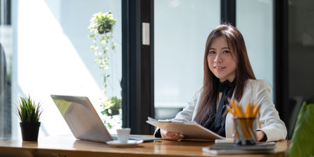 Portrait of smiling beautiful business asian woman working in office use computer. looking camera.の写真素材