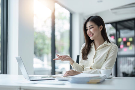 business young woman happy cheerful cute beautiful business woman sit in office using laptop computerの写真素材