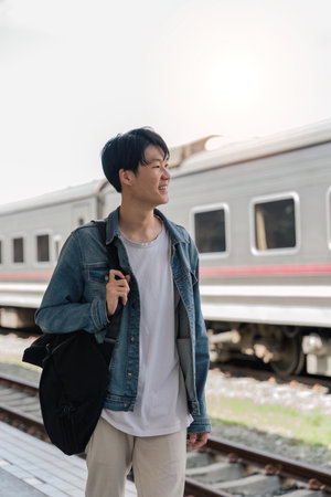 Young asian man travel by train. Freedom trip on vacation time holiday weekend