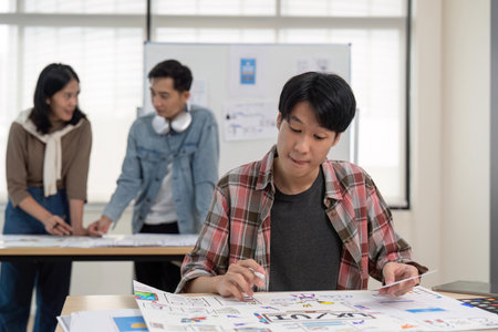 UX developer and UI designer brainstorming about app interface wireframe design on table with customer brief at modern office. Creative digital development agencyの写真素材