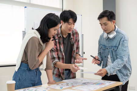 UX developer and UI designer brainstorming about app interface wireframe design on table with customer brief at modern office. Creative digital development agencyの写真素材