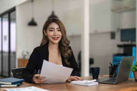Young asian business woman analysis finance graph company budget reportの写真素材