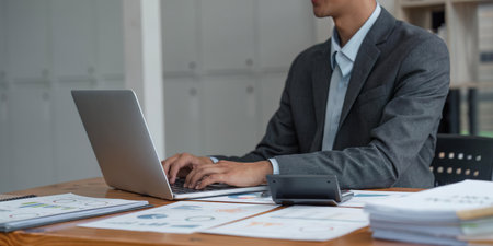 Business man working at office with laptop and documents on his deskの写真素材