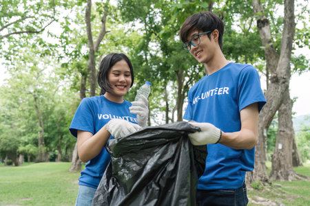 volunteering, charity, cleaning, young and ecology concept group of happy volunteers with garbage...