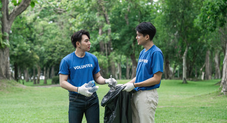 volunteering, charity, cleaning, young and ecology concept group of happy volunteers with garbage bags cleaning areaの写真素材