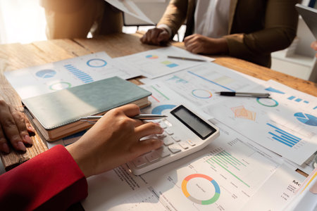 Business team meeting using calculator Work with charts and analyze business strategies. financial...