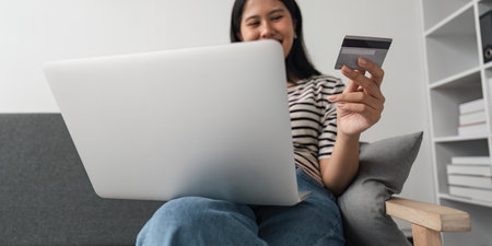 Asian young woman resting and browsing internet with Laptop holding credit card online shopping...