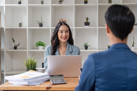 Two business at the office discuss about business strategy of new investments. Successful business people sitting together at a tableの写真素材