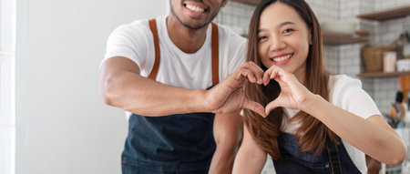 Love, a couple and heart hand sign man and woman together. Marriage, heart hands and relationship with support and trust in kitchenの写真素材