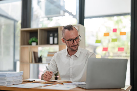 Business man working on project for analyzing company financial report balance statement with documents at modern office. business, economy, market, money and tax conceptの写真素材