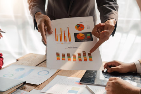 Business team analyzing income charts and graphs with modern laptop computer and digital tablet. Close up. Business analysis and strategy conceptの写真素材