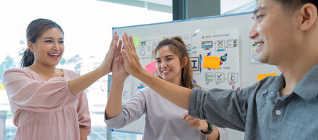 Group of designer cheerful giving high five on the success of website design and application on...