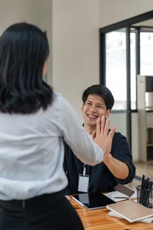 Business men and women giving high five a symbol of successの写真素材