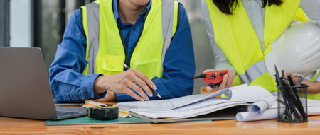 Two engineer working in office with blueprints, inspection in workplace for architectural plan,...