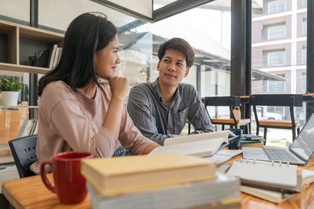 Male and female students reading a book. library research, reading and students with a book, learning knowledge at college. Scholarship, smile at university for educationの写真素材