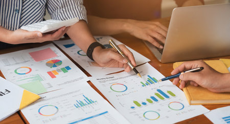 Business team analyzes financial business finance reports on laptop and graph documents during...