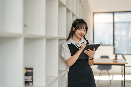 Online learning. Cheerful school studentgirl studying using digital tablet at homeの写真素材