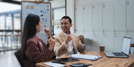 Businessmen Asians are determined and excited about their work. Business success corporate. Asian business team smiling and arms up after success job with partnerの写真素材