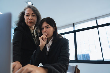 Teamwork collaboration senior manager explaining to an intern for digital trainingの写真素材