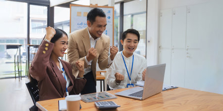 Businesspeople Asians are determined and excited about their work. Business success corporate. Asian business team smiling and arms up after success job with partnerの写真素材