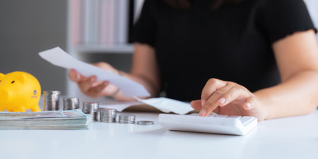 businesswomen is keeping a record of his income and expenses, he plans his finances by using his monthly savings to buy funds to make it grow faster. Concept of saving money for investmentの写真素材