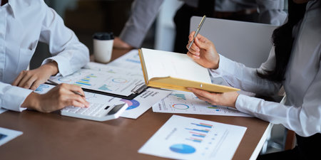Close up business team analyzes financial business finance reports on laptop and graph documents...