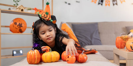 Cute little child girl with pumpkin balloon. Happy family preparing for Halloweenの写真素材
