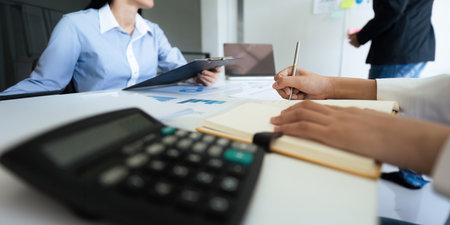 Asian business team is meeting for a project to establish and plan. Discussion of graphs and chart data analysis business finance graph and accounting conceptの写真素材