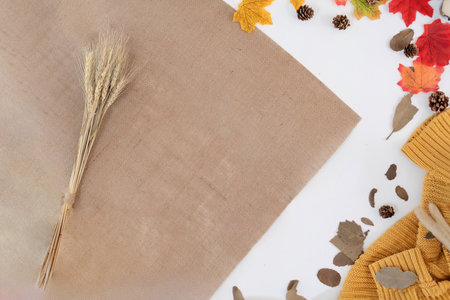 Modern office desk with yellow-red autumn leaves on white background with copy space. Place for your...